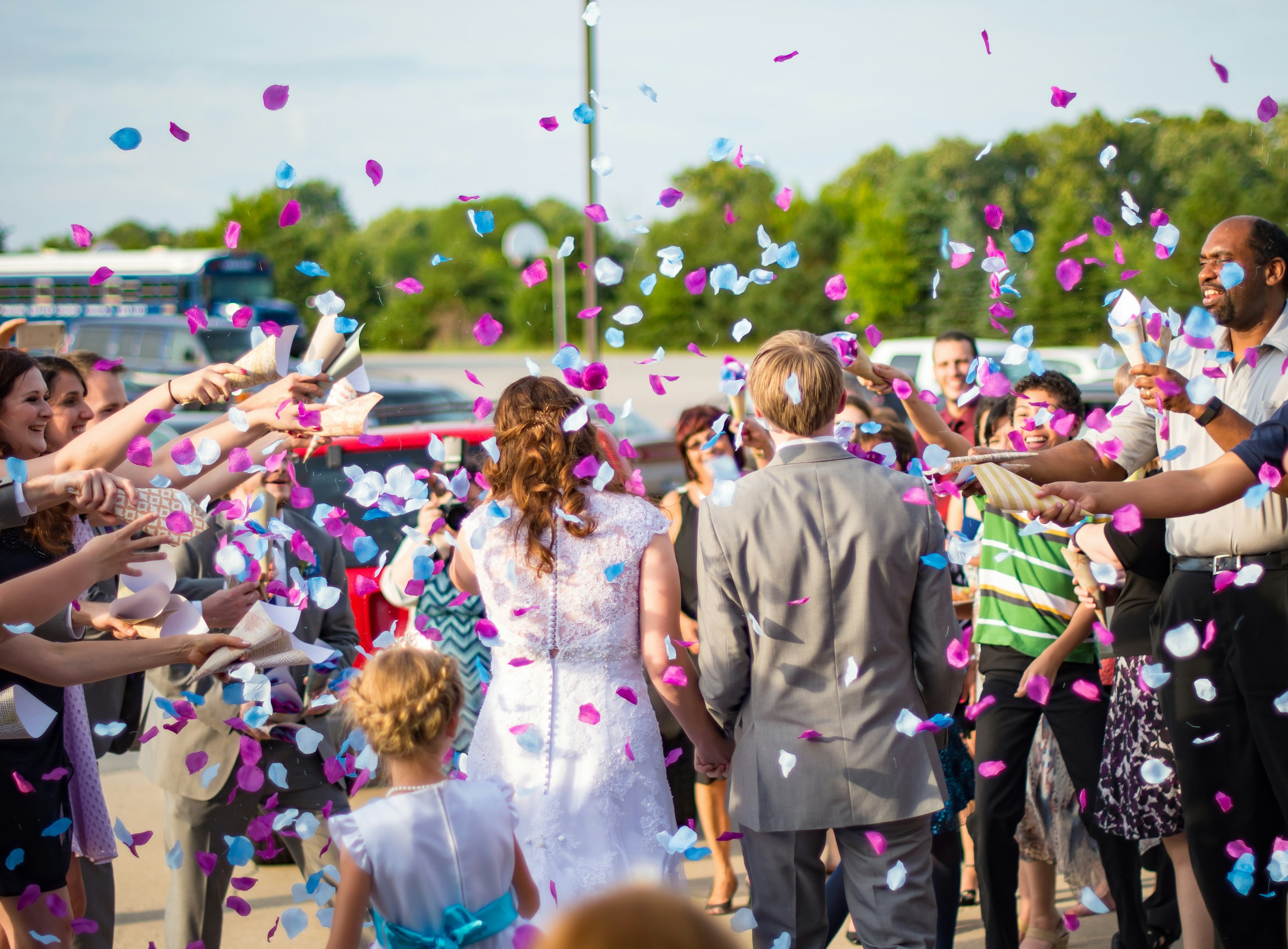 Gasten gooien kleurrijke confetti over het bruidspaar na de ceremonie