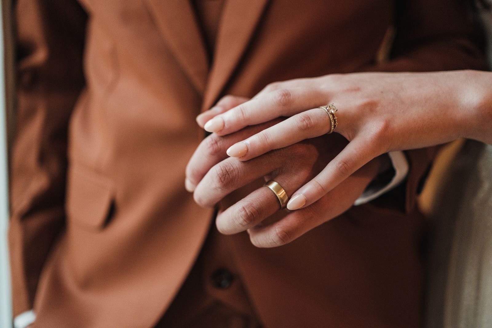 Close-up van de handen van een stel dat trouwringen draagt